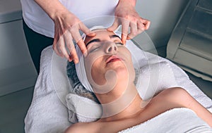 Woman receiving facial treatment on clinical center