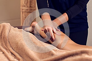 Woman receiving and enjoying a foot massage at the spa salon photo