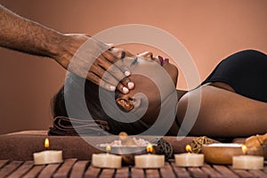 Woman Receiving Forehead Massage In Spa