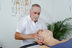 Woman receiving head massage from physiotherapist in clinic