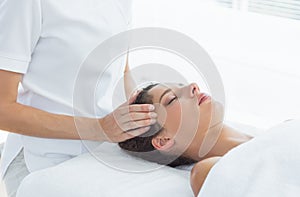 Woman receiving head massage from therapist