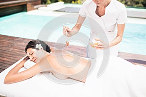 Woman receiving a honey massage from masseur