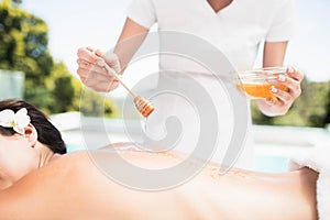 Woman receiving a honey massage from masseur