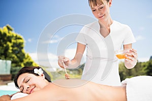 Woman receiving a honey massage from masseur