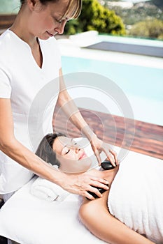 Woman receiving a hot stone massage from masseur