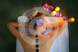 Woman receiving hot stone massage treatment at luxury spa