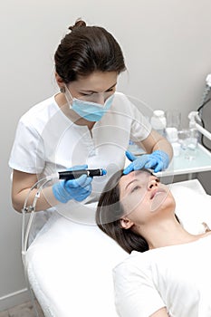 Woman receiving hydrafacial treatment in beauty salon