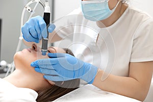 Woman receiving hydrafacial treatment in beauty salon