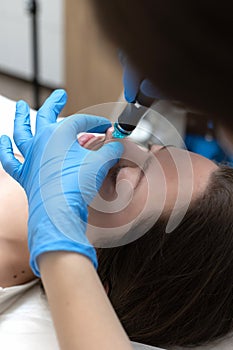 Woman receiving hydrafacial treatment in beauty salon