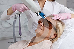 Woman receiving laser treatment in cosmetology clinic