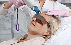 Woman receiving laser treatment in cosmetology clinic