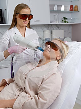 Woman receiving laser treatment in cosmetology clinic