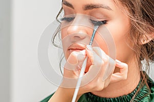 Woman receiving makeup for eyelashes