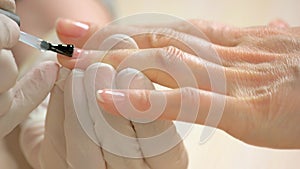 Woman receiving manicure in beauty salon.