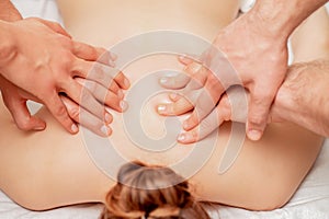 Woman receiving massage in four hands