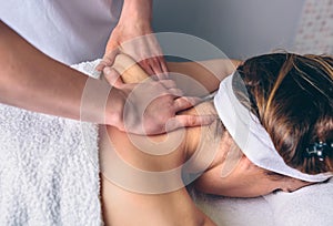 Woman receiving massage on shoulders in clinical center