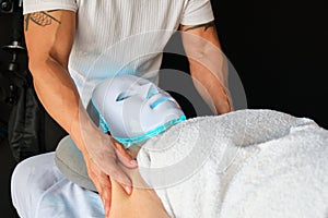 Woman receiving a massage while wearing blue led light phototherapy facial mask.