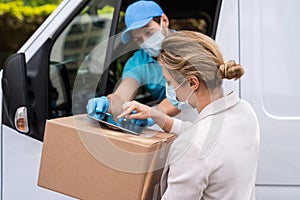 Woman receiving package from the delivery man on a van