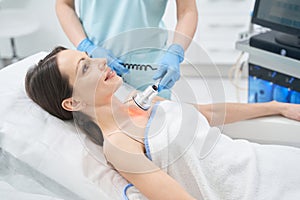 Woman receiving radiofrequency treatment in beauty center
