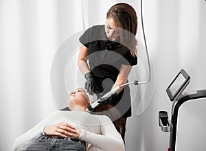 Woman receiving radiofrequency treatment in beauty clinic. photo