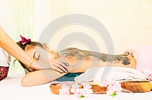 Woman is receiving Spa Charcoal Scrub in Spa