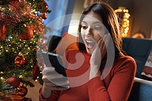 Woman receiving a surprise on her phone for Christmas