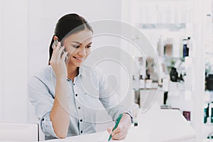 Woman Receptionist Speaks by Phone in Beauty Salon