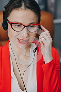 Woman receptionist wear headset consulting customer looking at computer talking with client in online computer chat