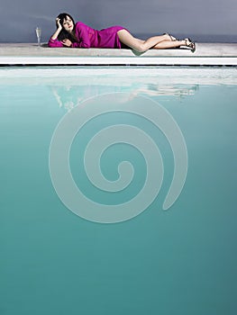 Woman Reclining By Pool With Champagne Glass