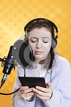 Woman recording audiobook, reading text from tablet, portraying characters