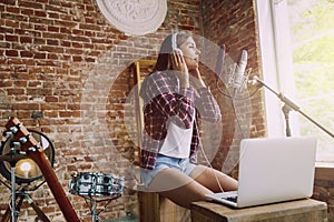 Woman recording music, broadcasting and singing at home