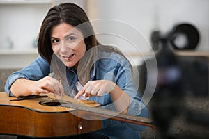 woman recording tutorial showing how to repair guitar strings
