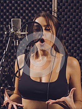 Woman recording vocals in the music studio