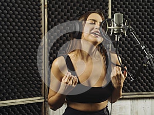 Woman recording vocals in the music studio