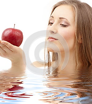 Woman with red apple in water
