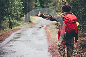 Woman with red backpack hitchhiking alone