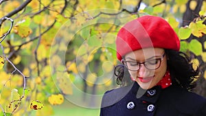 The woman in the red beret adjusts her glasses and thinks