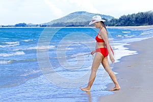Woman with red bikini walk on beach at Ban Krut