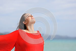 Woman in red breathing and relaxing on the beach