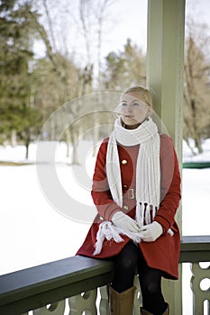 Woman in red coat dreaming at boundary