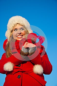 Woman in red coat holding heart shape