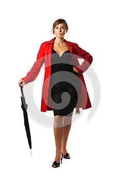 A woman in a red coat and holding an umbrella