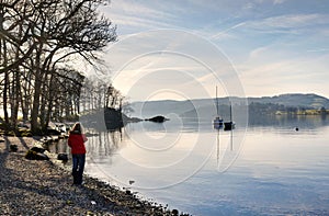 Woman in a red coat on the shore of Windermere