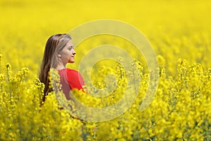 Woman in red contemplating in a yellow field