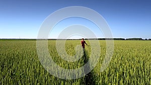 Woman in red dress crosses boundless commercial field