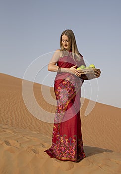 Woman in a red dress in a desert in Abu Dhabi