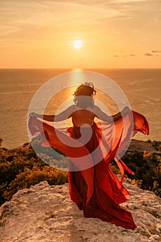 Woman in red dress, fashion model in evening dress, soaring in the street, sunset