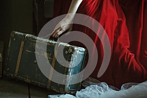 Woman in red dress holding a luggage