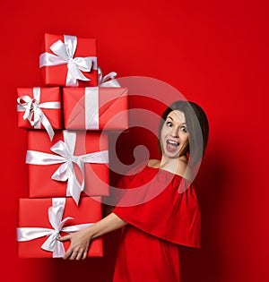 Woman in red dress holding many boxes