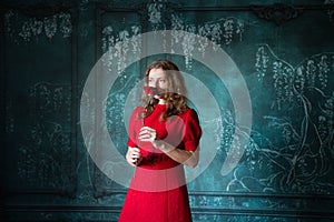 woman in red dress holding red rose